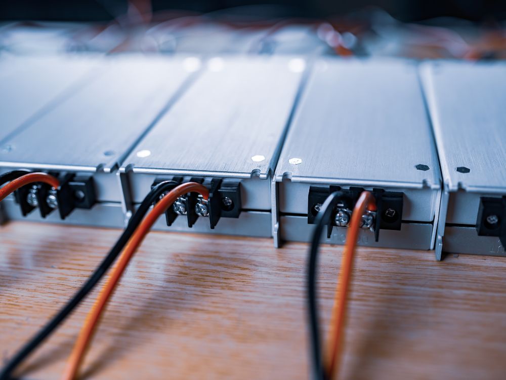 Cabos preto e vermelho conectados em módulos elétricos conforme o Padrão de cores dos fios elétricos ABNT para evitar falhas técnicas.