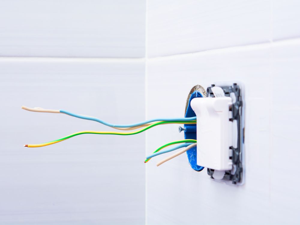 Fios elétricos expostos em uma caixa de passagem, situação que pode facilitar curtos-circuitos e exemplificar o que é fuga de corrente em instalações.