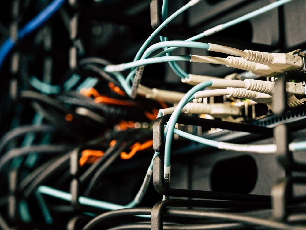 Conexões elétricas e cabeamento estruturado alimentados por sistema trifásico em ambiente técnico.